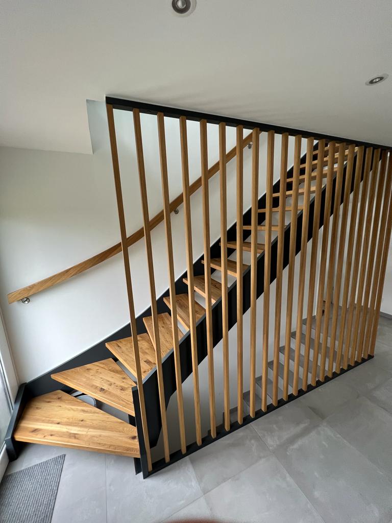 W-14  Holzwangentreppe, ¼ gewendelt, Stufen aus Eiche  rustikal gebeizt, Wangen in Anthrazit, Lamellenwand, Wandhandlauf