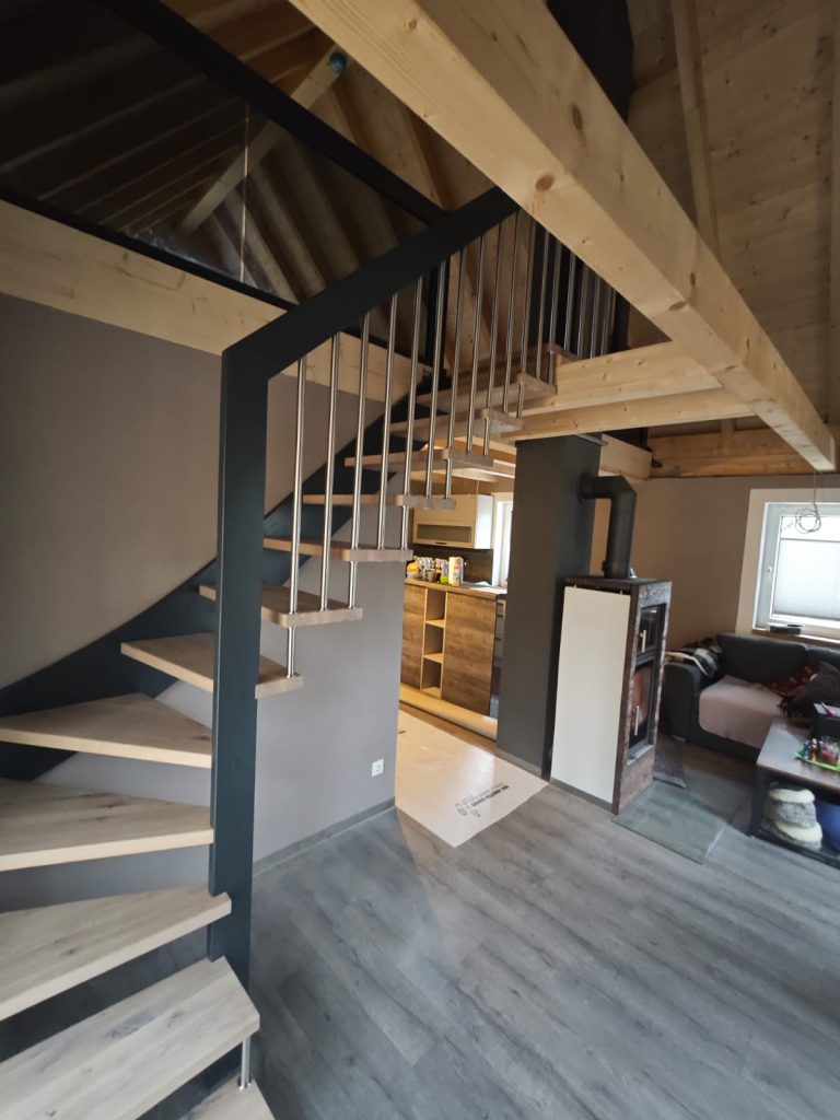 W-20 Holzwangentreppe, Handlauftragende, ¼ gewendelt, Edelstahlstäben, Stufen aus Eiche rustikal gebeizt, Wangen in Anthrazit, Rauchglas