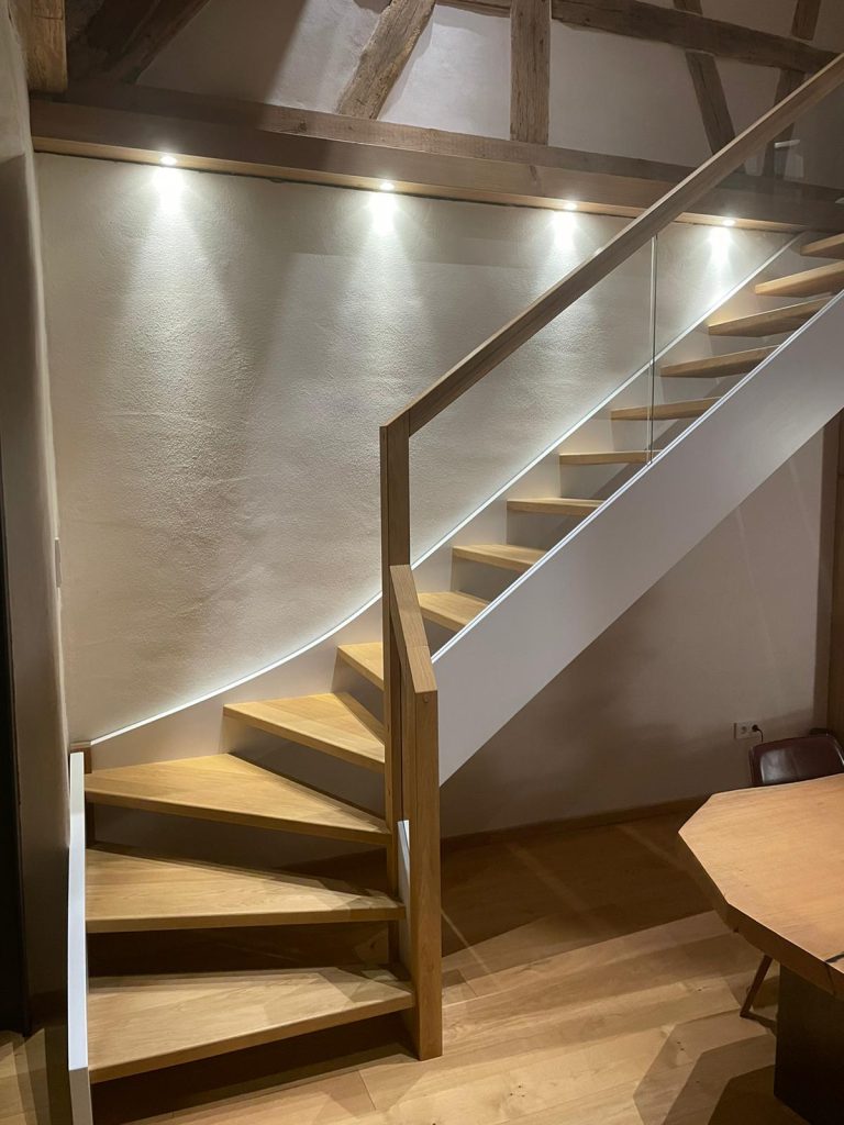 W-27 Holzwangentreppe, ¼ gewendelt, Stufen aus Eiche AB, Wangen in Weiß, Klarglas