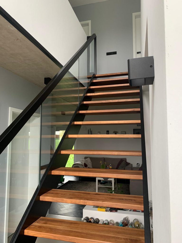 W-30 Holzwangentreppe, gerade, Stufen aus Nussbaum, Glasgeländer, Klarglas, Wangen in Schwarz