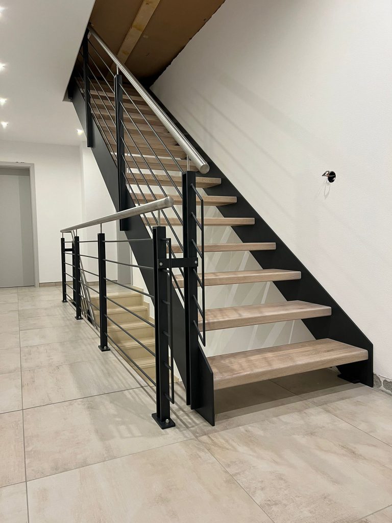 W-40 Stahlwangentreppe in Schwarz, gerade, Stufen aus Eiche AB gebeizt, Stahlgeländer mit Edelstahlhandlauf, Treppengeländer