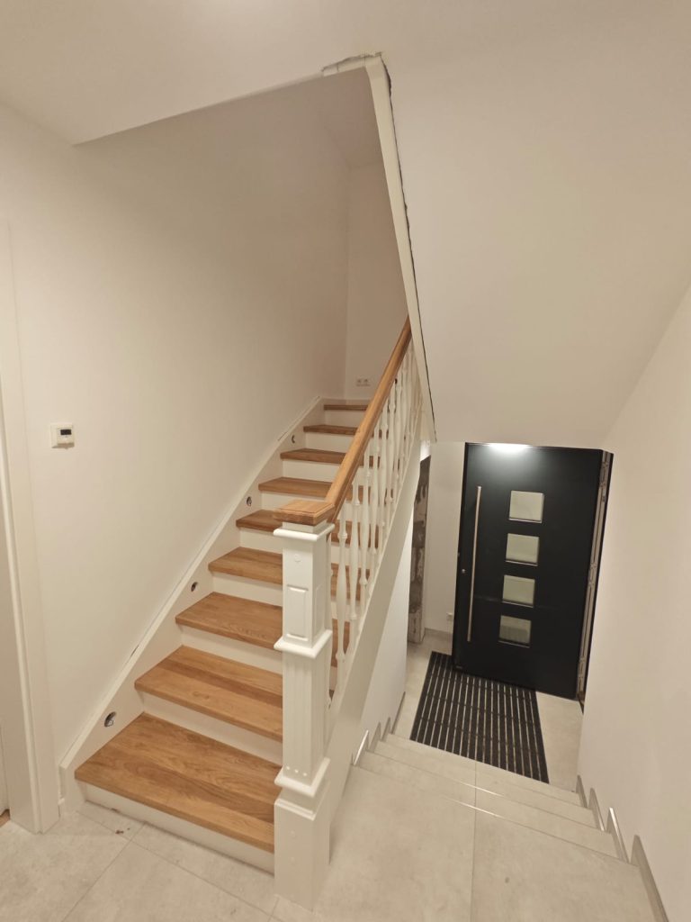 B-2 Holztreppe auf Betontreppe, ½ gewendelt mit Podest, Stufen aus Eiche AB, Wangen in Weiß