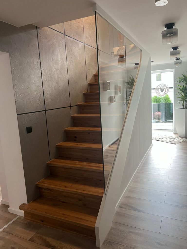 B-3 Stufen auf Betontreppe, ¼ gewendelt, Stufen aus Eiche rustikal, Wangen in Weiß, Glas von Wange bis Decke, Ganzglasgeländer, Aluminiumschiene, Glastür,