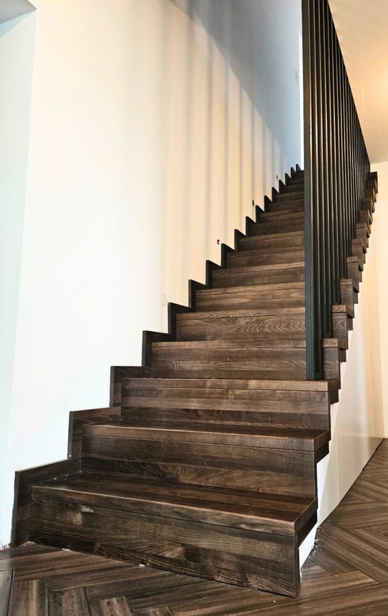 B-7 Holztreppe auf Betontreppe, Gerade, Ganze Treppe aus Esche gebeizt, Stahlgeländer bis Decke