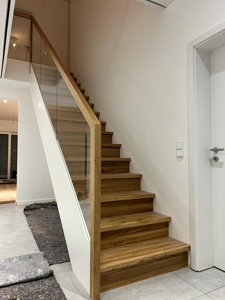 B-1 Holztreppe auf Betontreppe, Stufen aus Eiche AB, Wangen in Weiß, Glasgeländer, Klarglas, Deckenlochverkleidung