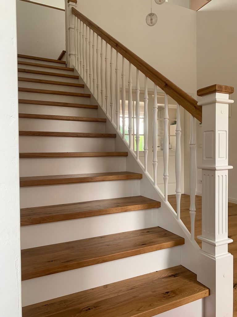 B-5 Holztreppe auf Betontreppe, ¼ gewendelt mit Podest, Stufen aus Eiche rustikal, Wangen in Weiß, Extra Pfosten